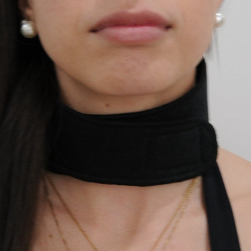 Woman wearing a black swimsuit against a plain background