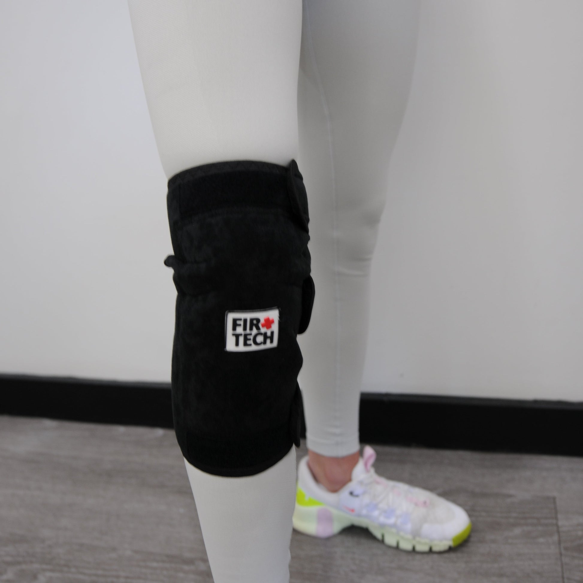 Person wearing black boxing gloves with a brand logo on a neutral background
