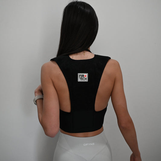 Person wearing a black sports bra with a visible brand logo on a plain background